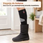 Noga w podgrzewanej podkolanówce wsuwana do wysokiego zimowego buta, sterownik wystaje nad cholewką, jasne tło sieni