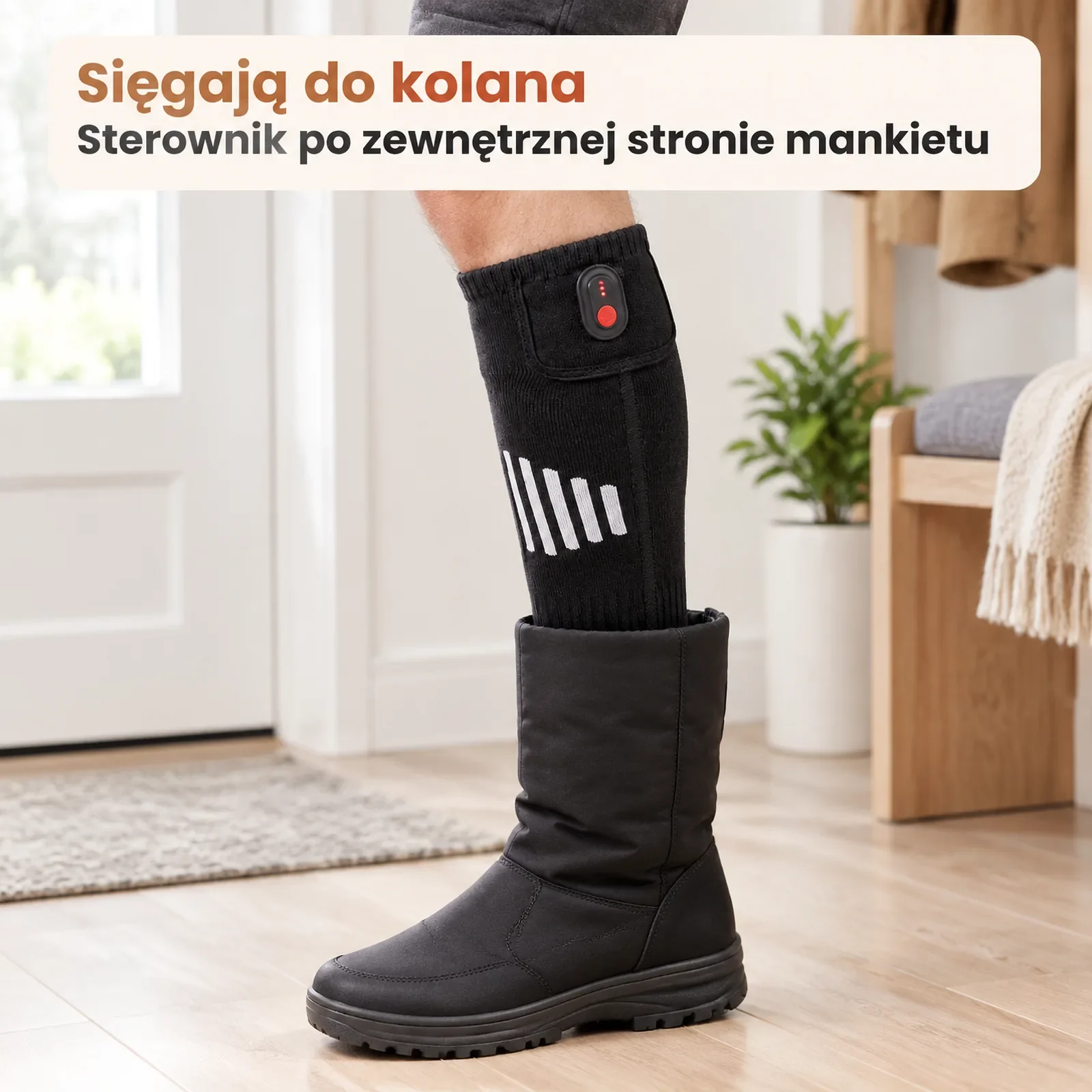 Noga w podgrzewanej podkolanówce wsuwana do wysokiego zimowego buta, sterownik wystaje nad cholewką, jasne tło sieni